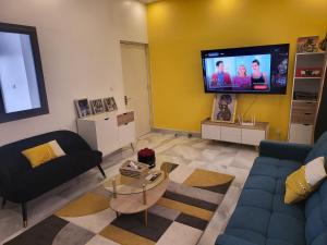 a living room with a couch and a tv at Belle VILLA Apt Mamelles, Monument de la renaissance arrondissement ALMADIES in Ouakam
