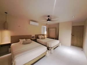 una camera da letto con due letti e un ventilatore a soffitto di Ka 3 Merida a Mérida
