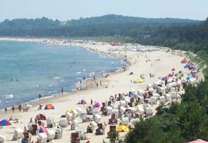 una playa con un montón de sombrillas y gente en ella en Haus Lena, en Ostseebad Sellin