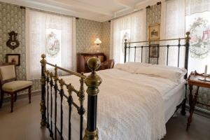 a bedroom with a large bed and a chair at Lundins Hotell in Karmøy