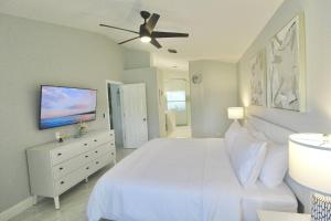 a bedroom with a white bed and a ceiling fan at Blue Haven Villa 3 Bedroom 2 Bathroom Home in Port Saint Lucie +34 photos
