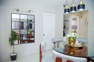 Un comedor con una mesa de cristal y sillas. en Luxury 2 bedroom Apartment, en Santiago de los Caballeros