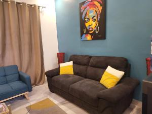 a living room with a brown couch with yellow pillows at Belle VILLA Apt Mamelles, Monument de la renaissance arrondissement ALMADIES in Ouakam