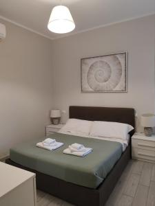 une chambre avec un lit avec deux serviettes dessus dans l'établissement Maison Blanche, à Varazze