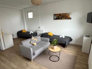 a living room with a couch and a bed at Appart hôtel Doumer in Triel-sur-Seine