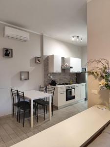 une cuisine et une salle à manger avec une table et des chaises dans l'établissement Maison Blanche, à Varazze