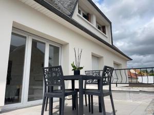 a black table and two chairs on a balcony at Appart hôtel Doumer in Triel-sur-Seine