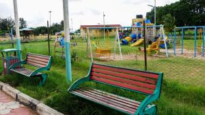 two benches in a park with a playground at Pavillion Apartments in Malindi