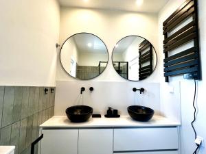a bathroom with two sinks and two mirrors at Charming and peaceful apartment, Cascais center in Cascais +35 photos