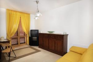sala de estar con sofá y TV en Appartamenti Le Terme en Rapolano Terme