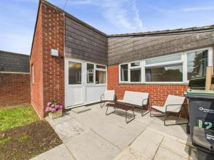 a patio with chairs and a brick building at MODERN 2 BED BUNGALOW SLEEPS 4 Pet friendly in Calne +6 photos
