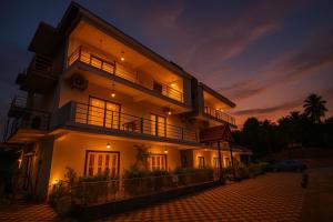un edificio illuminato con un'auto parcheggiata di fronte di In GOA Three Bedroom Penthouse with Kitchen a Candolim