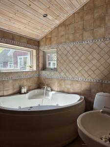 a bathroom with a large tub and a sink at Gatans Gård sekelskiftshus 
