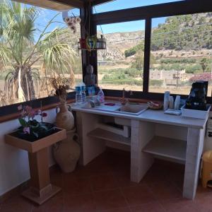 a kitchen with a desk and a large window at La Foggia seaside paradise in Siculiana
