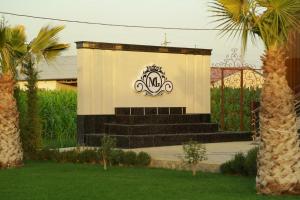 a building with a gate and stairs with a sign at Milano Garden Plaza Samarkand in Samarkand