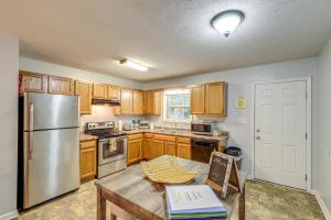a kitchen with wooden cabinets and a stainless steel refrigerator at 3 Mi to Cherokee Reservoir Blue Haven Bungalow in Morristown +19 photos