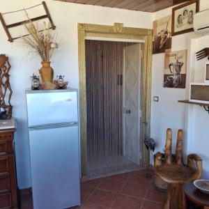 a kitchen with a white refrigerator and a door at La Foggia seaside paradise in Siculiana