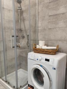 une machine à laver avec un panier dessus dans une salle de bain dans l'établissement Maison Blanche, à Varazze