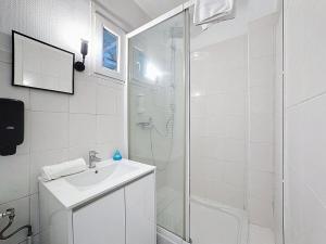 a white bathroom with a shower and a sink at Studio 2 personnes avec parking et balcon Proudhon in Clermont-Ferrand