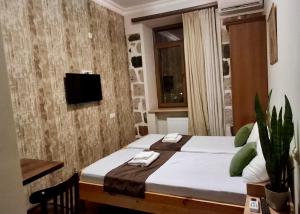 a bedroom with a bed and a tv on a wall at Cascade Heritage Inn in Yerevan