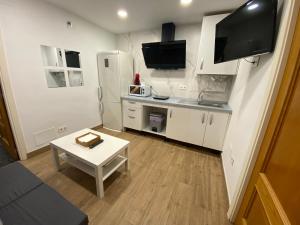 a small kitchen with a refrigerator and a table at Arcaro Beach in Málaga
