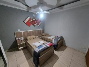 a room with two beds and a ceiling fan at Hotel Luar in Sao Paulo