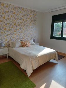 a bedroom with a large bed with a wall at A casa da Piruleta in Bueu
