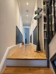 un corridoio con pavimento in legno e un cartello sul muro di Seaweed Suite, secluded seaside stay with garden view a Newquay