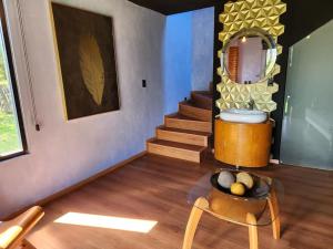 a room with a staircase and a table and a mirror at El CIELO HOTEL BOUTIQUE in San Miguel Ajusco
