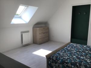 a bedroom with a bed and a dresser and a window at Maison à la campagne, proche de Guingamp in Ploumagoar