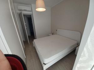 a small white bed in a small room at straccia 2 in Cupra Marittima