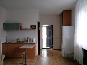 een keuken met een koelkast en een tafel. bij Уютная квартира в коттедже в центральной части города in Kaliningrad