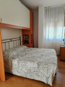 una camera da letto con un letto e una finestra di Attico Alghe Rosse Jesolo lido a Lido di Jesolo