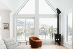 a living room with a large window and a couch at Villas Perspective Alphonse Spa and Mountain in Beaupré