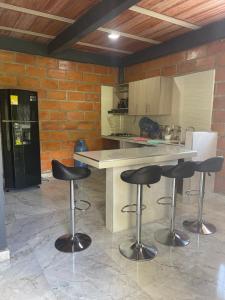 a kitchen with three bar stools and a counter at chalet Relajante, En San Rafael in San Rafael