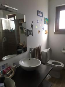 a bathroom with a sink and a toilet and a mirror at Casa da Âncora in Colares +4 photos