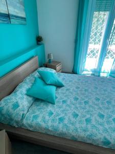 a blue bedroom with a bed with two blue pillows at Aria di Mare in Lido di Ostia