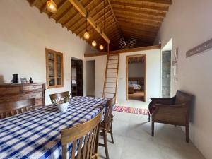 a dining room with a table and chairs and a ladder at Casa da Eira in Faial da Terra