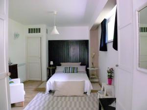 Invito al viaggio في جيارديني ناكسوس: غرفة نوم مع سرير أبيض مع اللوح الأمامي الأسود