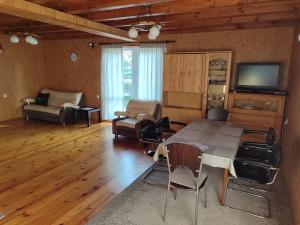 a living room with a table and chairs and a television at Wypoczynek w Orzynach in Orzyny