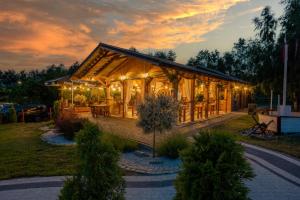 a house with lights on it in the evening at Boogie House domki nad morzem in Jarosławiec
