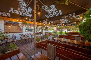 a patio with wooden benches and tables and lights at Boogie House domki nad morzem in Jarosławiec