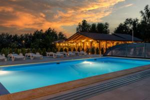 a resort swimming pool with a building in the background at Boogie House domki nad morzem in Jarosławiec