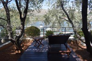 a chair and a table on a deck with trees at Apartments Tonka Grebaštica in Grebaštica