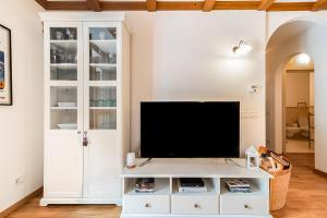 a living room with a tv on a white entertainment center at Giardino sul Lago - Vista su lago e montagne a Molveno in Molveno
