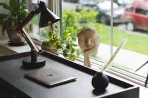 a desk with a lamp and a wooden head on a window at Ace Properties in Chicago