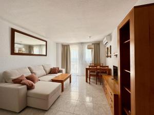 a living room with a white couch and a table at BENIDORM SKYLiNE in Benidorm