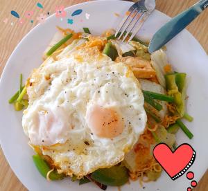 a plate of food with eggs on top of vegetables at Hugo's Family in Da Lat +28 photos