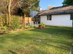 a yard with two chairs and a house at Chestnut Cottage New Forest in Brockenhurst