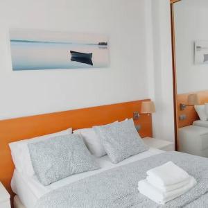 Schlafzimmer mit einem Bett mit einem Kopfteil aus Holz und Kissen in der Unterkunft Apartamento Aeropuerto Suite 2 2 3 E in Madrid